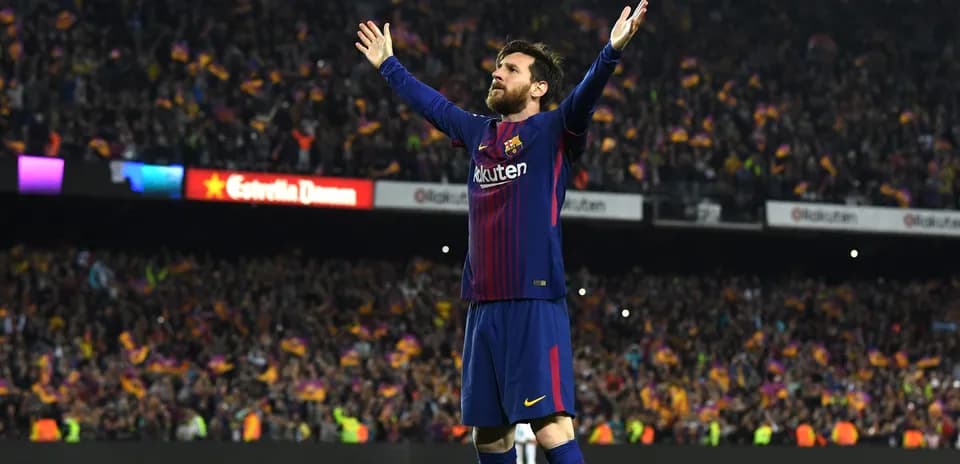Joueur levant les bras devant des supporters de Barcelone