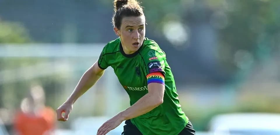Joueuse en action avec un maillot vert et brassard