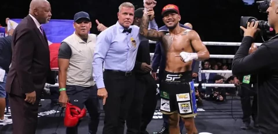 Boxeur célébrant sa victoire avec l'arbitre