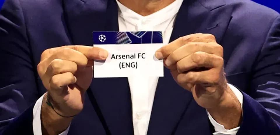Un homme tenant un carton avec Arsenal FC