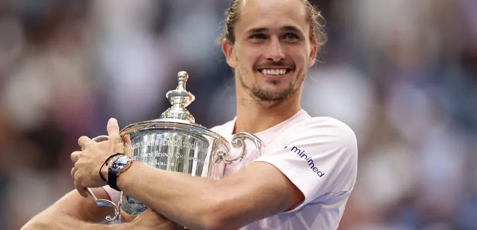 Joueur tenant le trophée de tennis avec un sourire