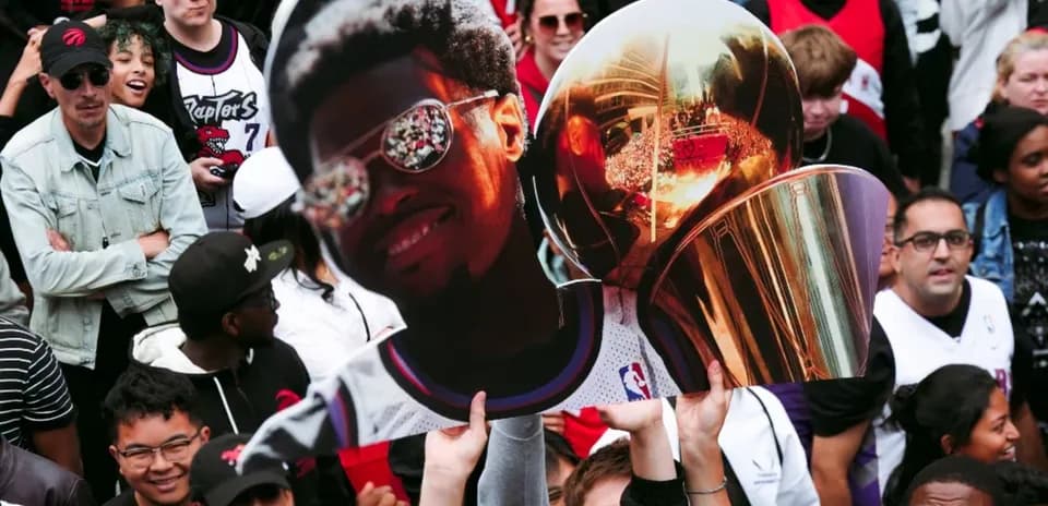Supporters holding a sign and trophy at celebration