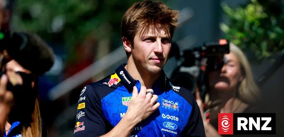 Pilote de Formule 1 en tenue d'équipe, regardant autour