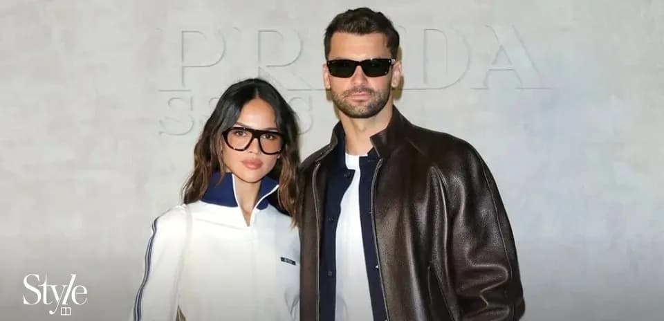 Couple posing in front of Prada backdrop