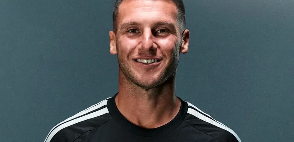 Joueur de football en maillot noir souriant