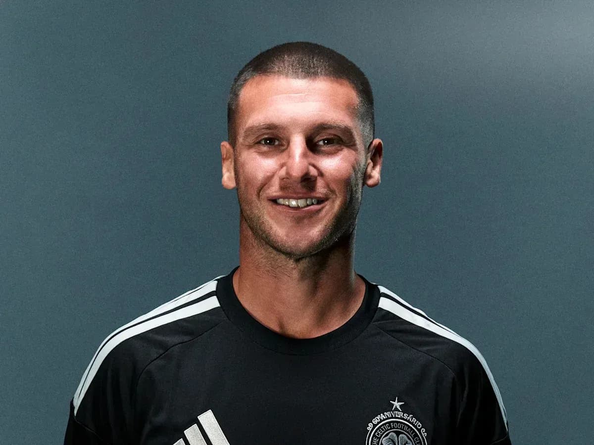 Joueur de football en maillot noir souriant