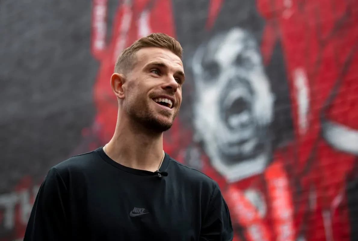 Joueur souriant devant une fresque murale rouge