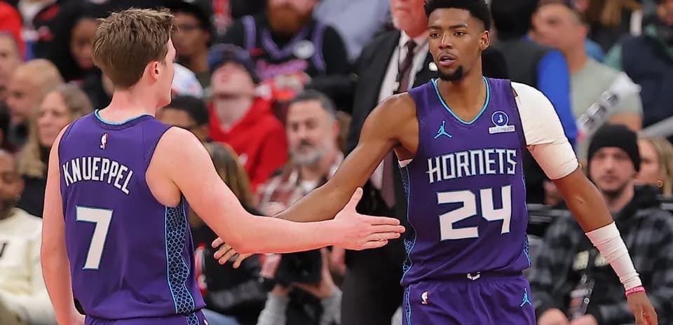 Deux joueurs des Hornets se serrant la main sur le terrain
