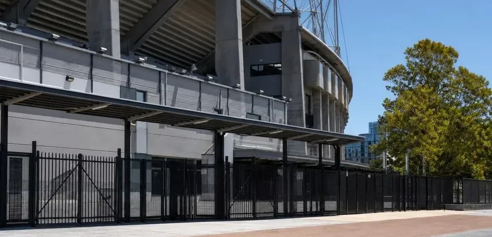 Vue extérieure du stade avec clôtures et végétation