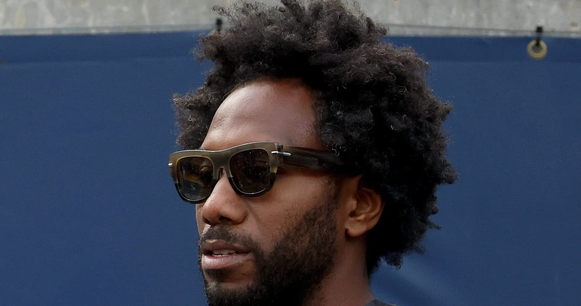 Homme avec des lunettes de soleil et cheveux crépus