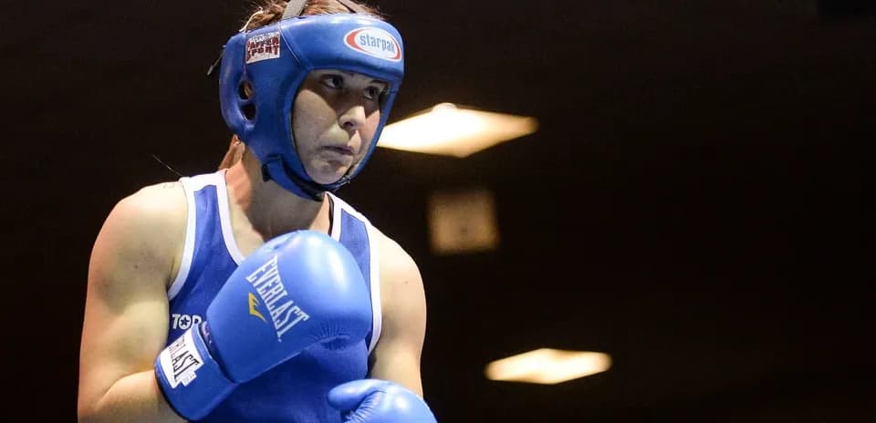 Boxeuse en action avec gants bleus et casque