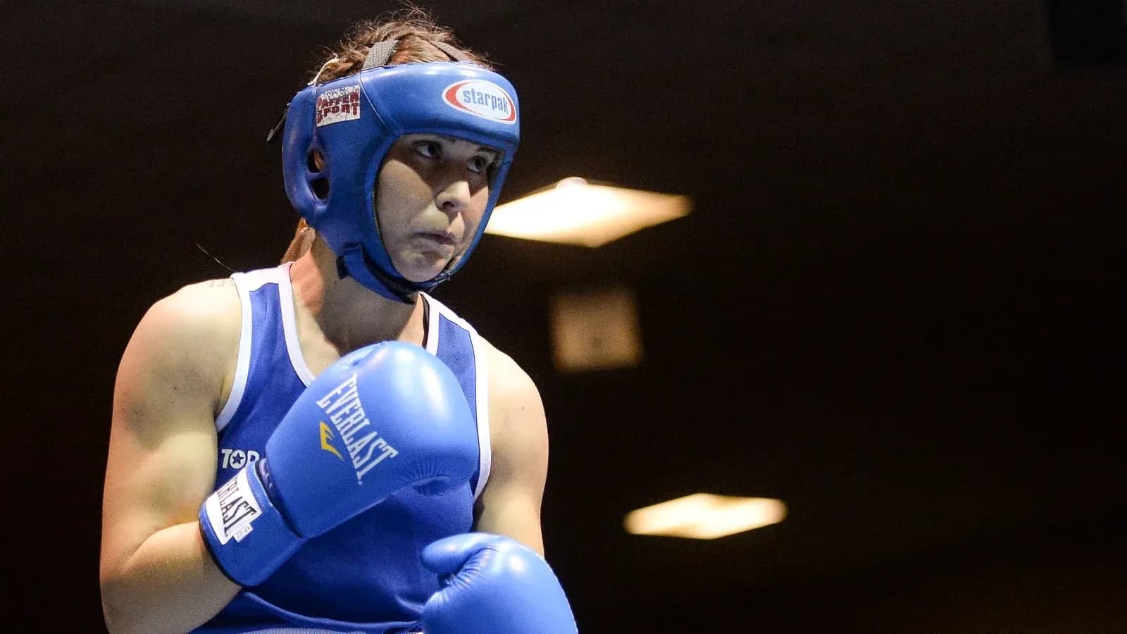 Boxeuse en action avec gants bleus et casque