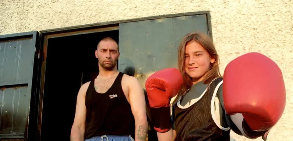 Fille en gants de boxe avec un homme à l'entrée