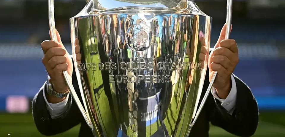 Trophée de la Ligue des champions UEFA en main
