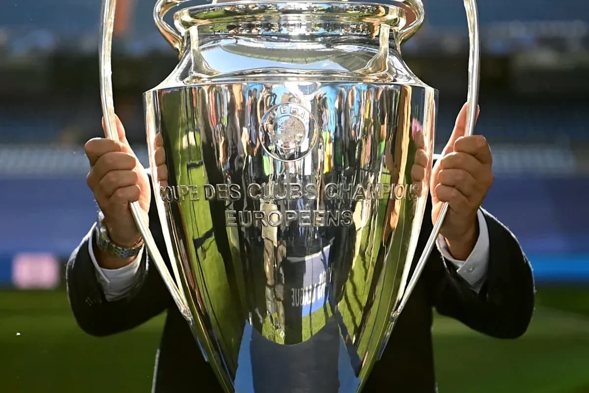 Trophée de la Ligue des champions UEFA en main
