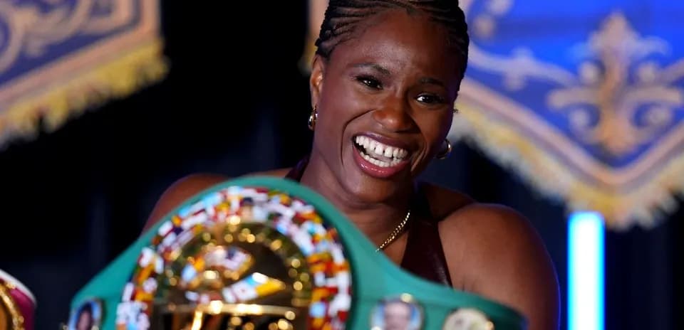 Boxeuse souriante tenant une ceinture de championne