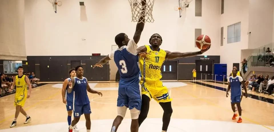 Joueur dunkant au panier pendant un match de basket
