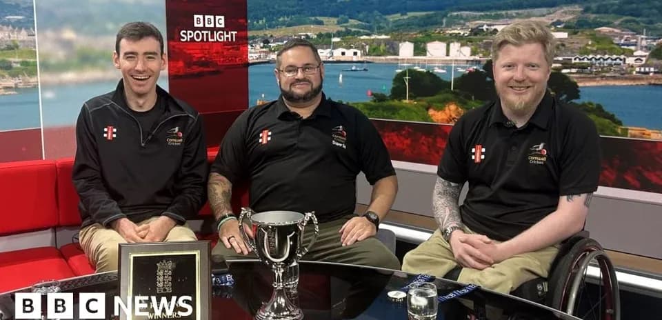 Trois personnes posant avec un trophée en studio