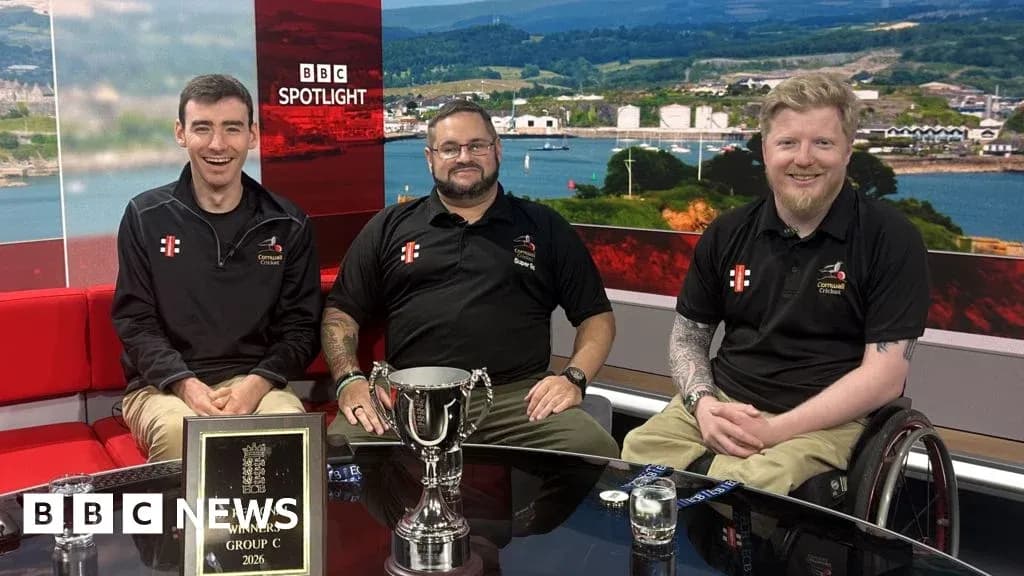 Trois personnes posant avec un trophée en studio