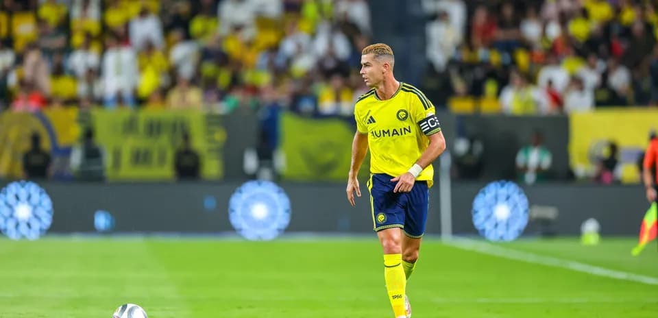 Joueur portant le maillot d'Al-Nassr avec un ballon