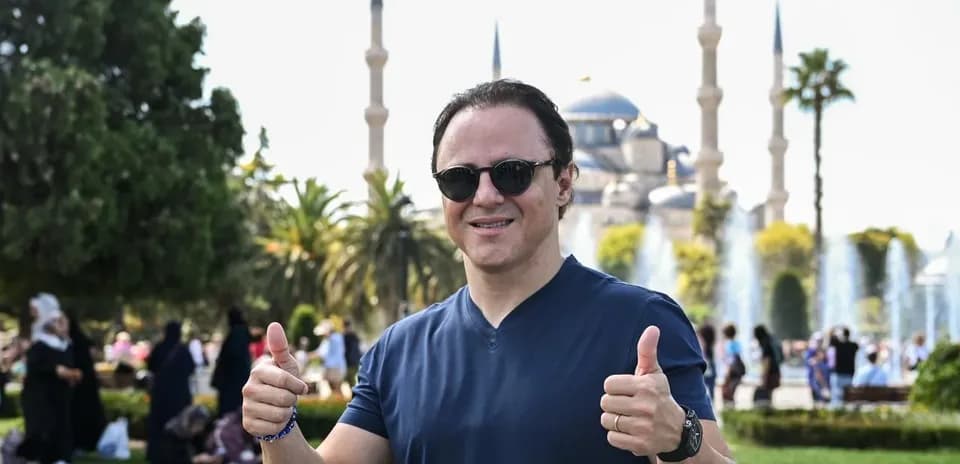 Homme faisant un pouce en l'air devant une mosquée