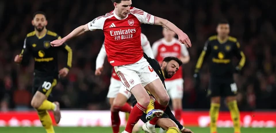 Joueur d'Arsenal en train de tomber après un tackle