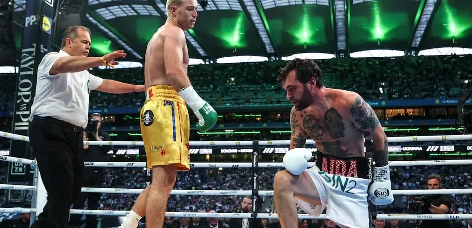 Boxer kneeling in ring with referee observing