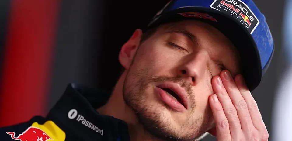 Pilote de F1 touchant son visage en conférence