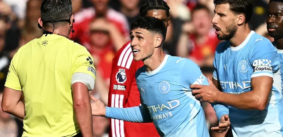 Joueur de Manchester City discutant avec l'arbitre