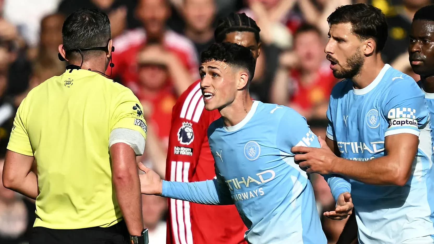 Joueur de Manchester City discutant avec l'arbitre