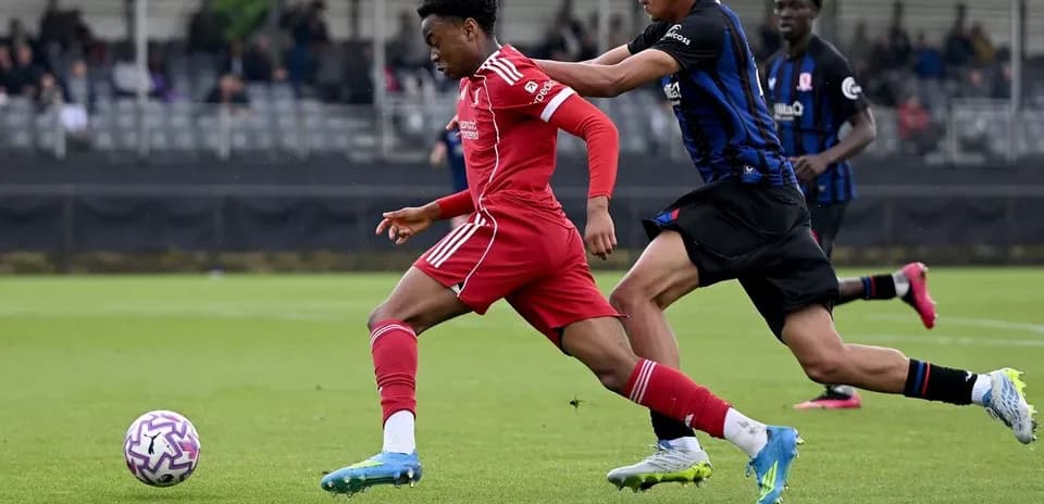 Joueur en maillot rouge dribblant un adversaire en noir