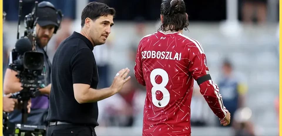 Entraîneur discutant avec joueur Szoboszlai sur le terrain
