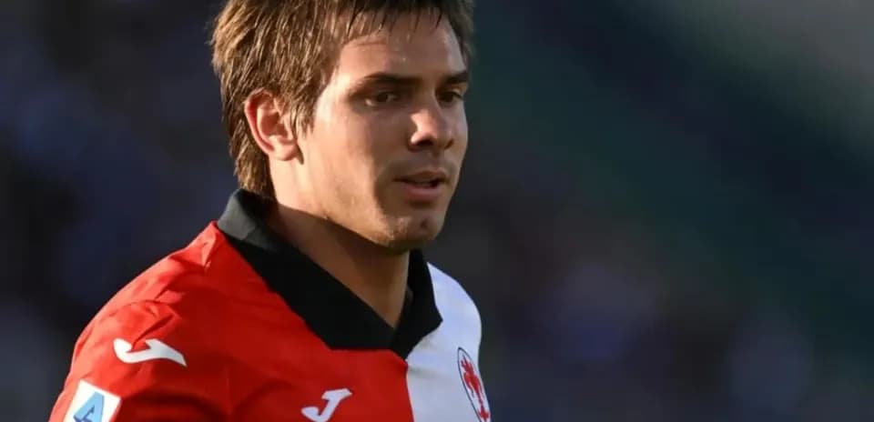 Joueur de football portant un maillot rouge et noir