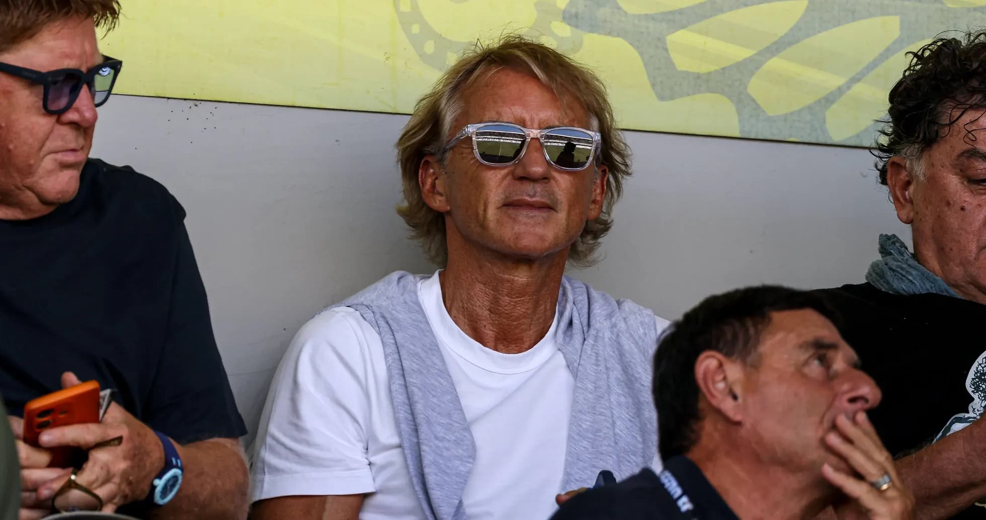 Homme assis portant des lunettes de soleil dans les gradins