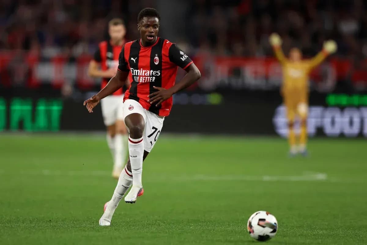 Joueur du Milan AC courant avec le ballon sur terrain