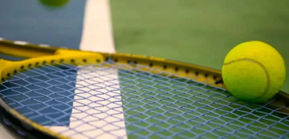 Balle de tennis sur une raquette sur le court