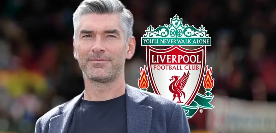 Homme souriant devant le logo de Liverpool FC