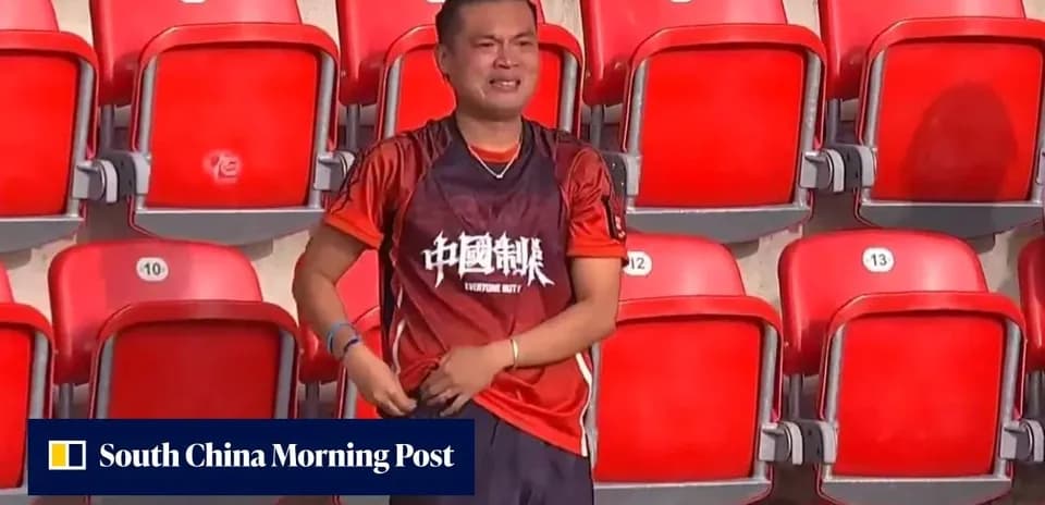 Supporter in red jersey standing in empty stadium