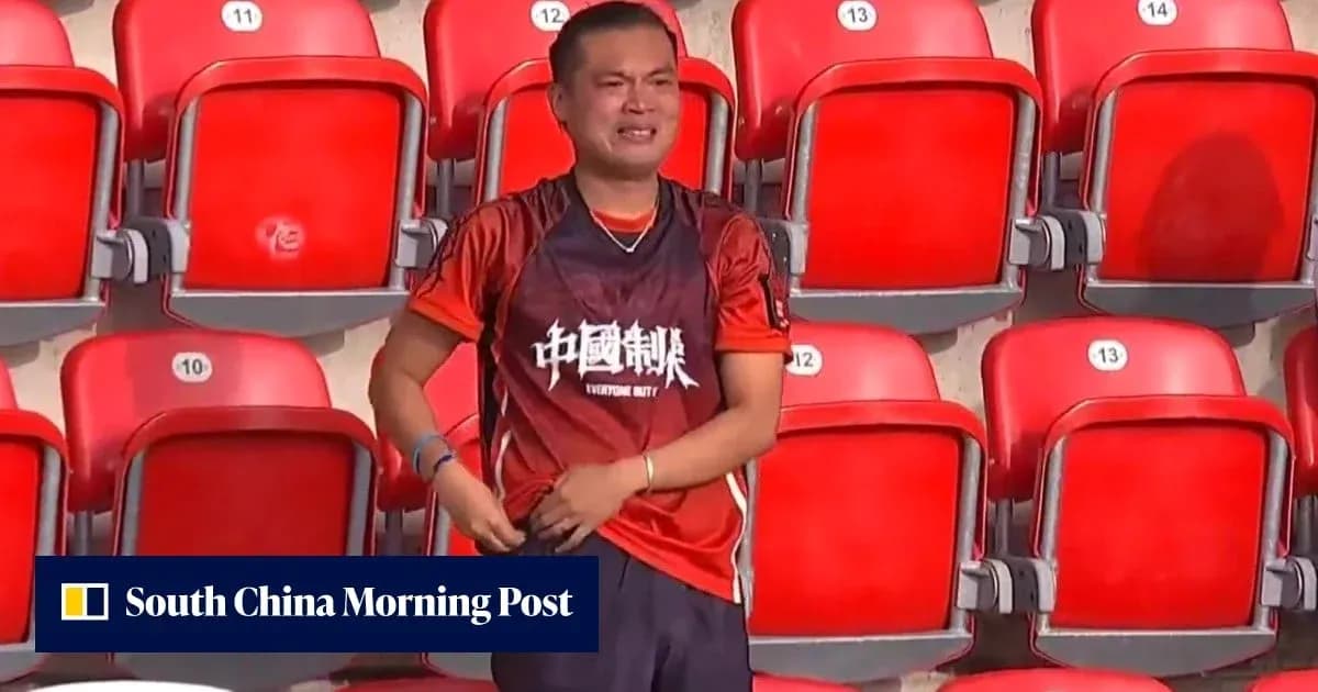 Supporter in red jersey standing in empty stadium