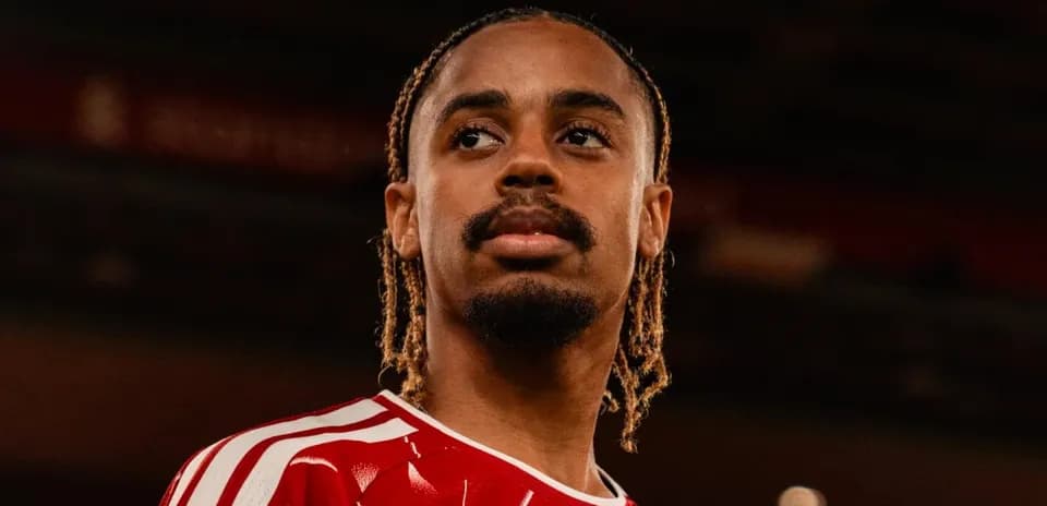 Joueur en maillot rouge, regard sérieux dans le stade