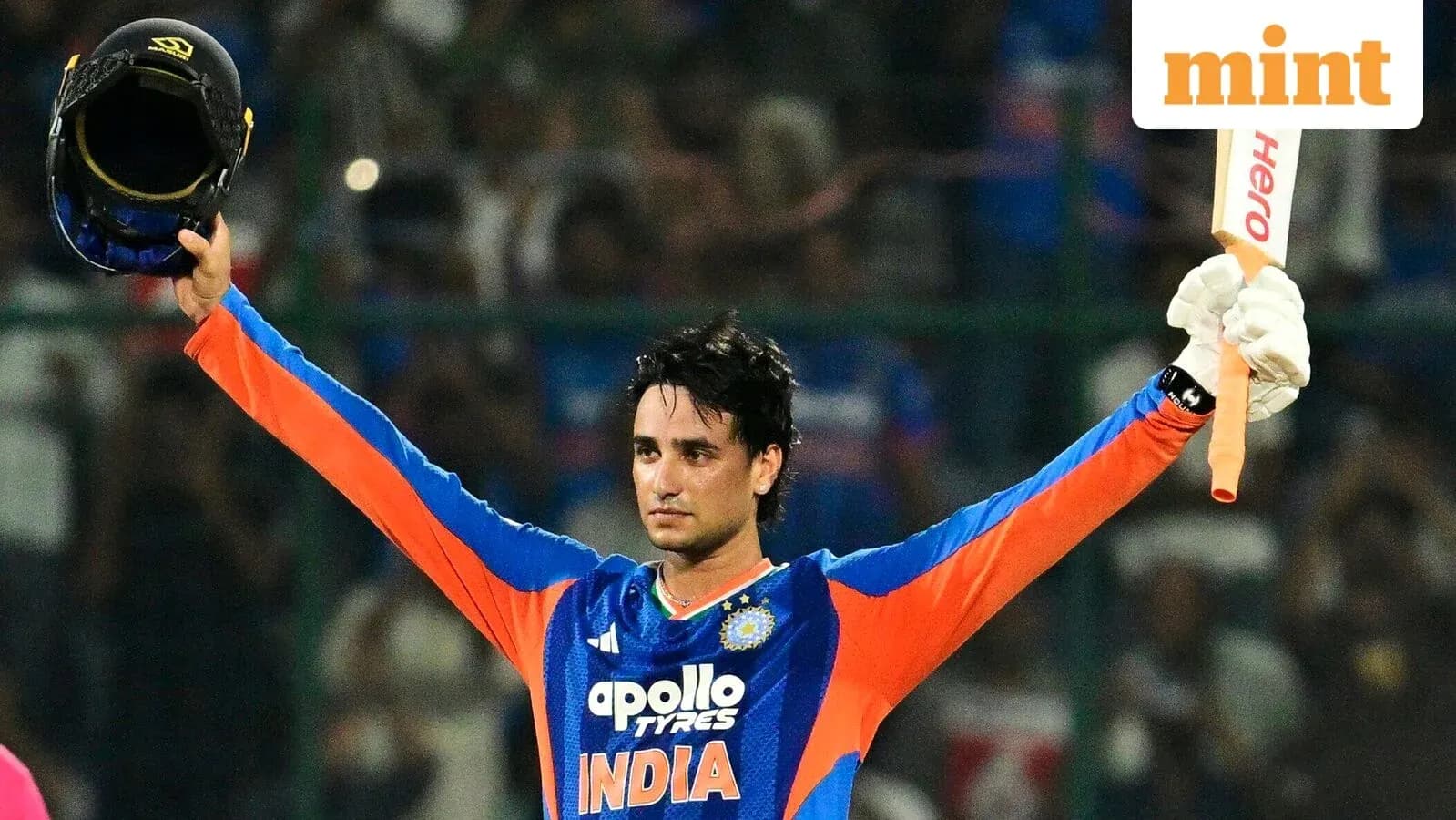 Joueur de cricket levant son casque et sa batte