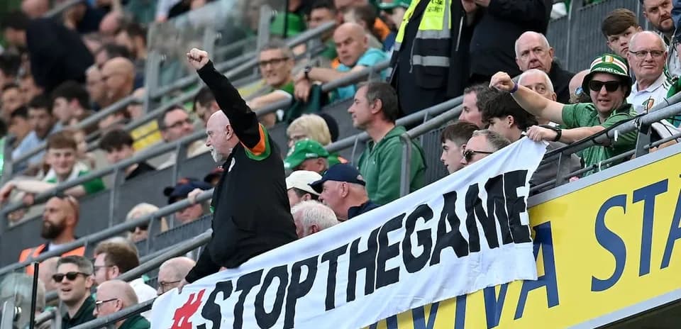 Supporters holding a banner at a stadium