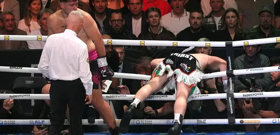 Boxer leaning over the ropes during a match