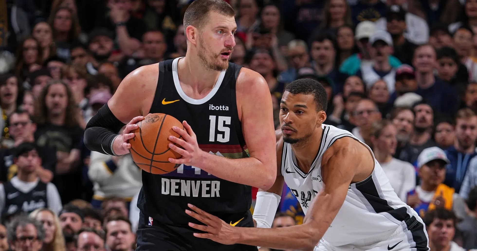 Joueur de Denver dribblant sous la pression de l'adversaire