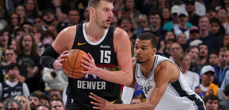 Joueur de Denver dribblant sous la pression de l'adversaire