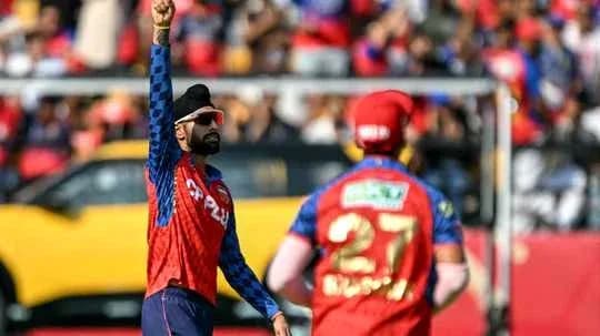 Joueur levant le bras pendant un match de cricket