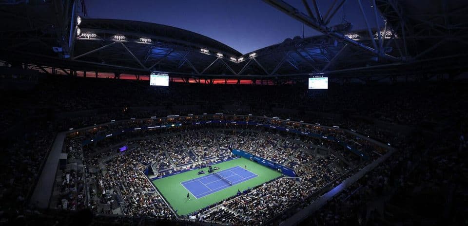 Stade de tennis rempli lors d'un match nocturne