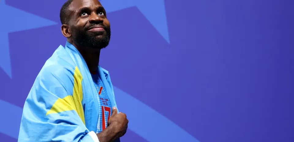 Athlete with flag smiling during event ceremony