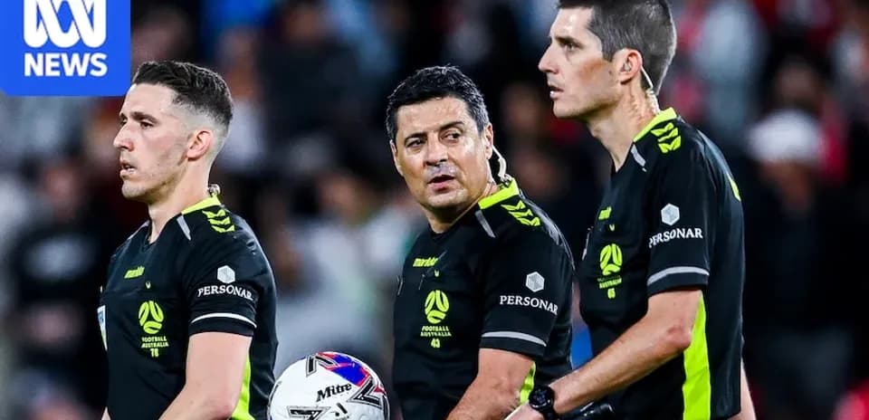 Trois arbitres discutant lors d'un match de football