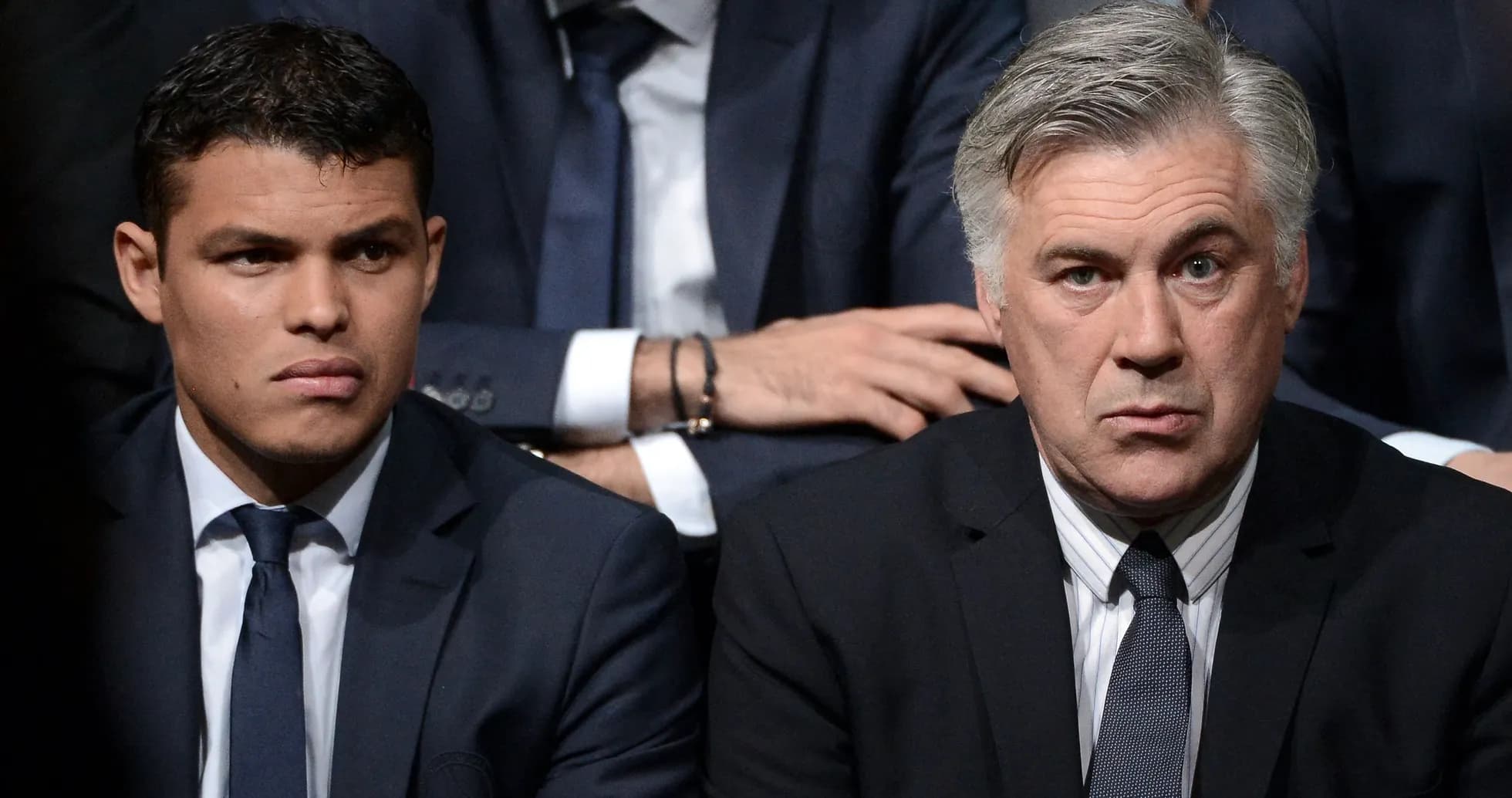 Deux hommes en costume assis lors d'un événement